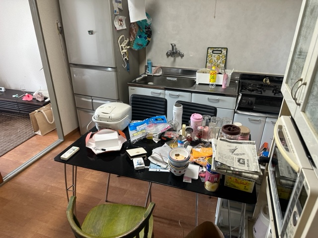 テーブルの上には汚れたままの食器や新聞紙が置かれ、冷蔵庫には生鮮食品も入っている状態